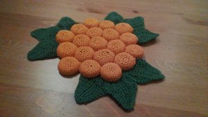 A trivet made of crocheted bottle caps