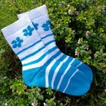 Striped blue and white colorwork socks with a short row heel and flower motif. Knitted with Filcolana Arwetta.