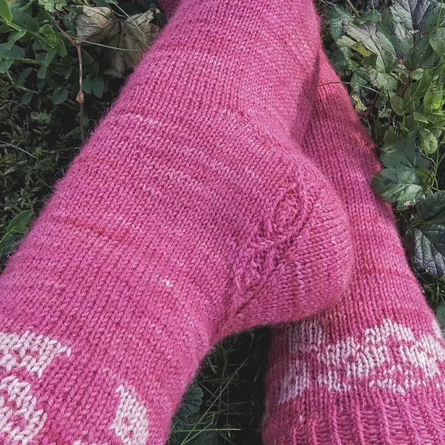 Pink knitted socks with a rose